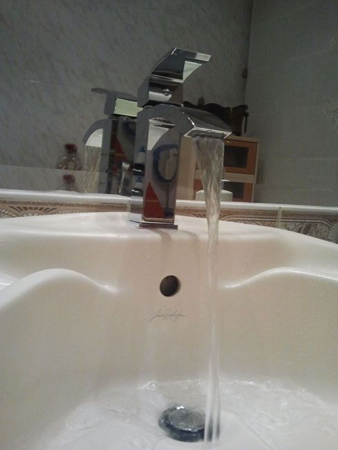 Un lavabo de baño con agua corriendo del grifo