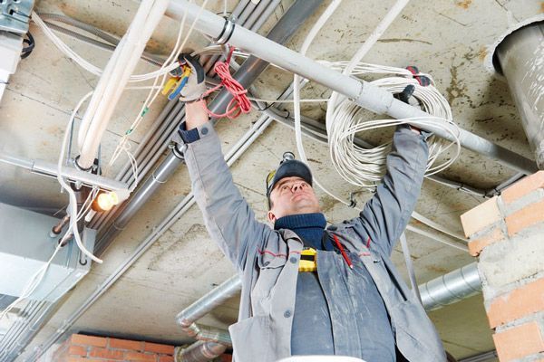 Un hombre está trabajando con cables eléctricos en un edificio.