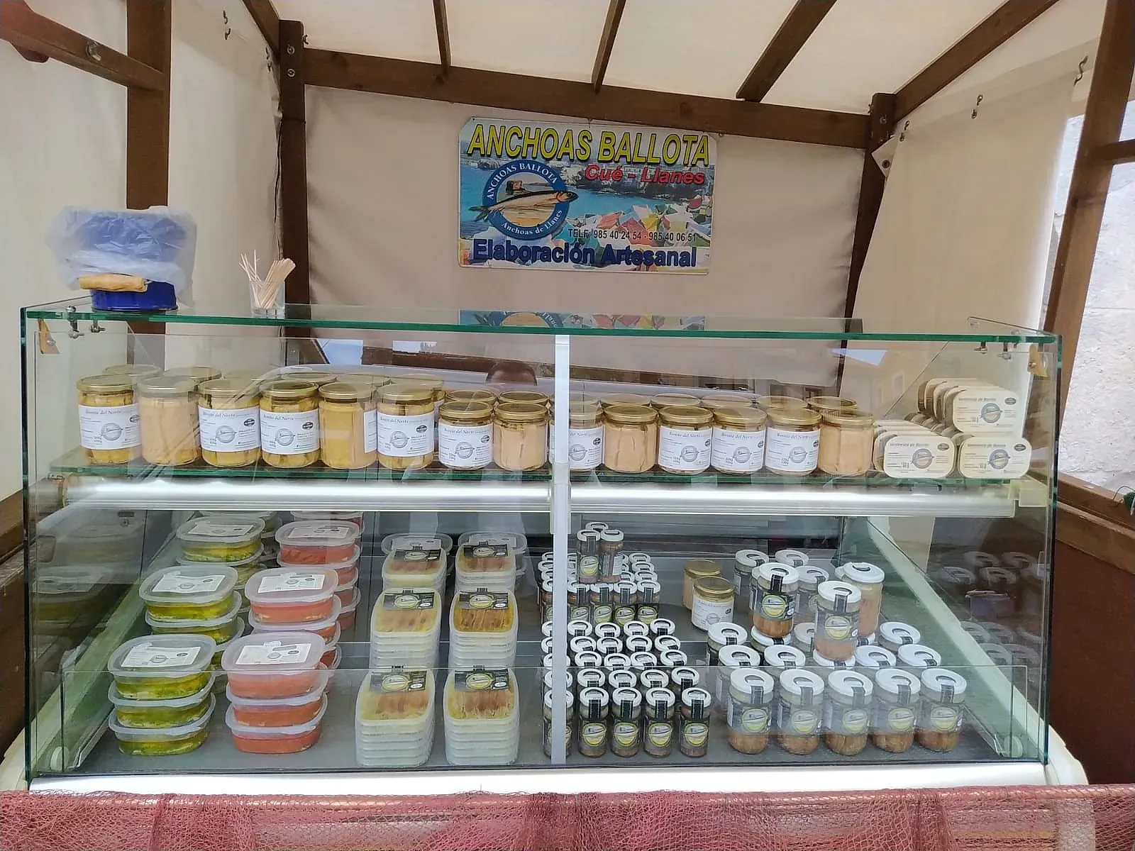 Una vitrina llena de frascos y recipientes de comida.