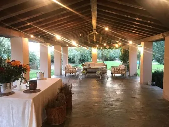 Una habitación grande con una mesa y sillas bajo un techo de madera.