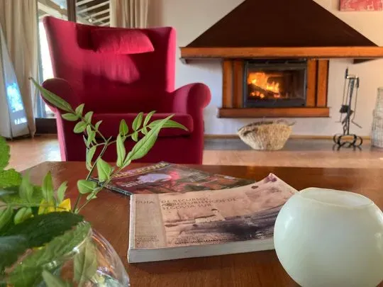 Una sala de estar con chimenea y una silla roja.
