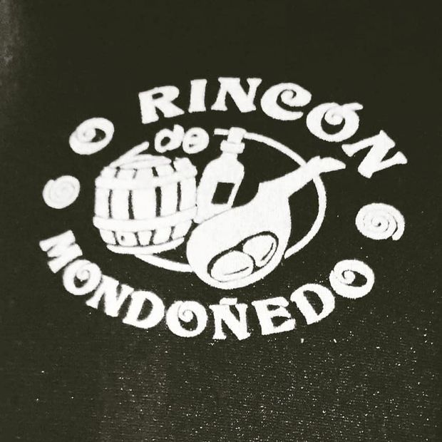 Logotipo de "Rincón de Mondoñedo" con un barril, una botella y un jamón, sobre fondo negro.