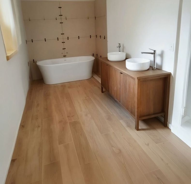 Salle de bains moderne avec baignoire îlot, meuble lavabo en bois et deux vasques sur un parquet clair
