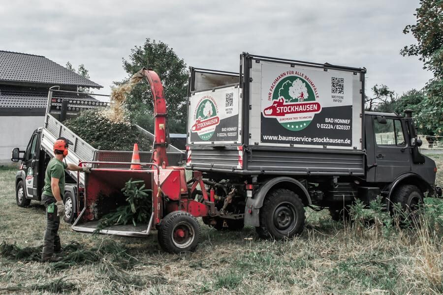 Ein Mann steht vor einem LKW mit der Aufschrift „Gartenwerk“