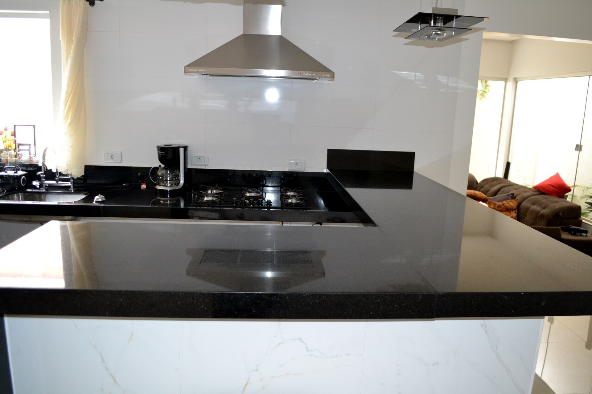 Uma cozinha com bancada preta e fogão com forno