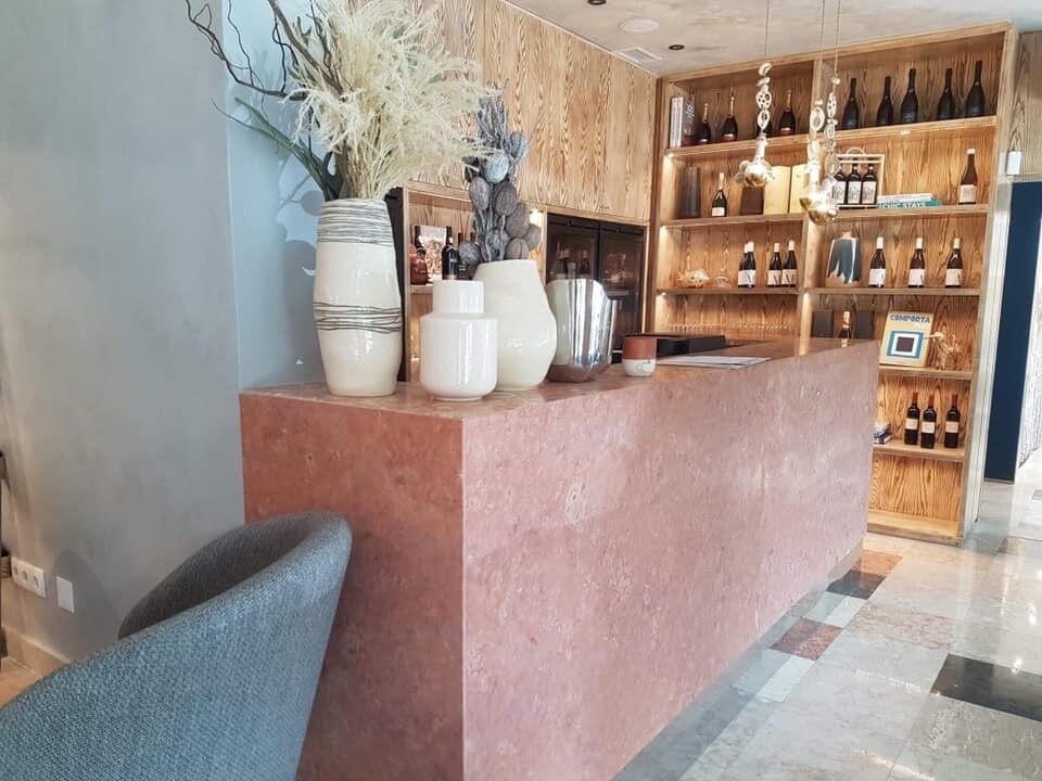 Um balcão rosa em um restaurante com vasos nele