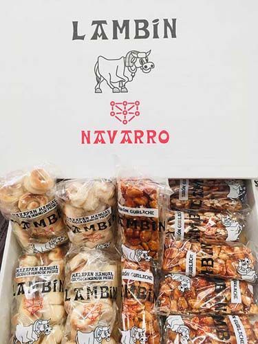 Logotipo de Lambin Navarro sobre una selección de pasteles envasados ​​en bolsas de color beige, marrón y naranja.