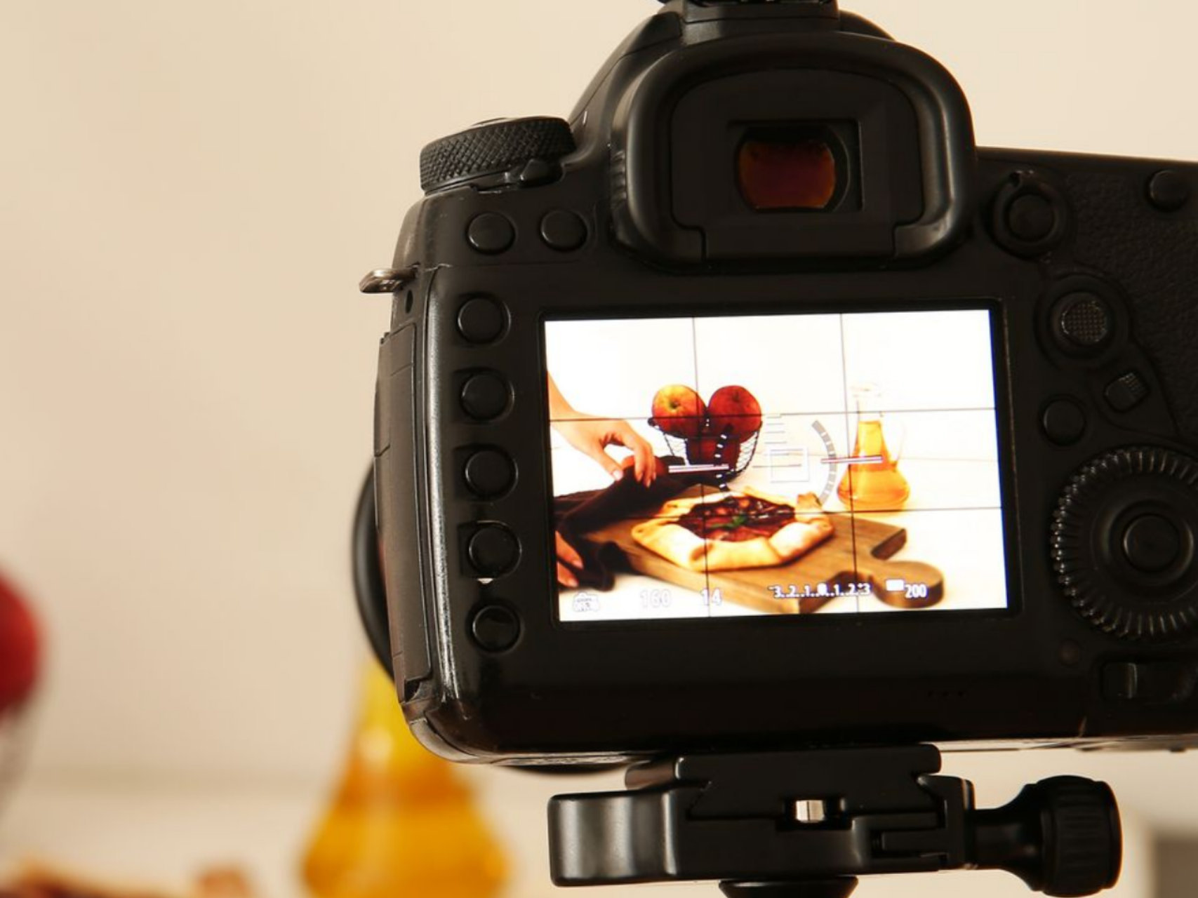 Caméra filmant une présentation culinaire avec des pommes et une tarte sur une planche en bois.