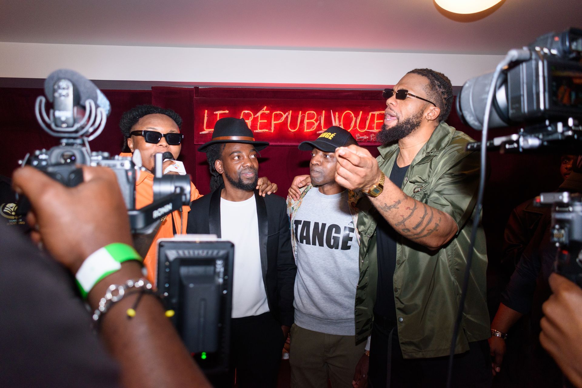 Une caméra sur trépied fait face à une scène éclairée avec un décor.