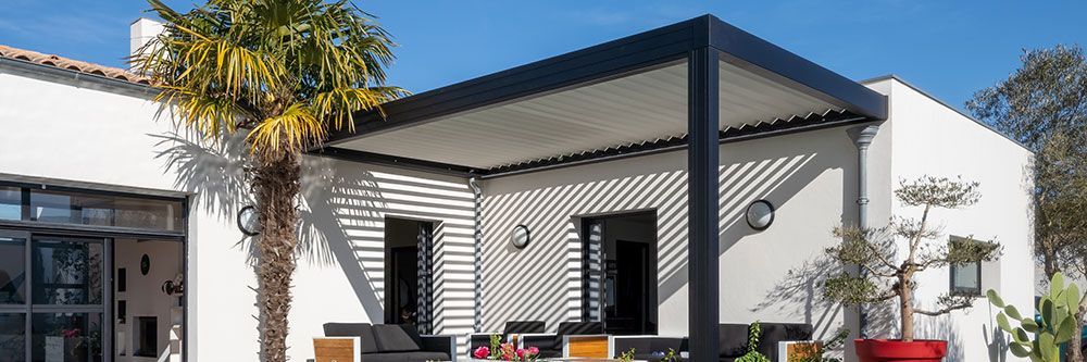 Pergola noire et blanche sur une terrasse collée à une maison moderne blanche à toit plat