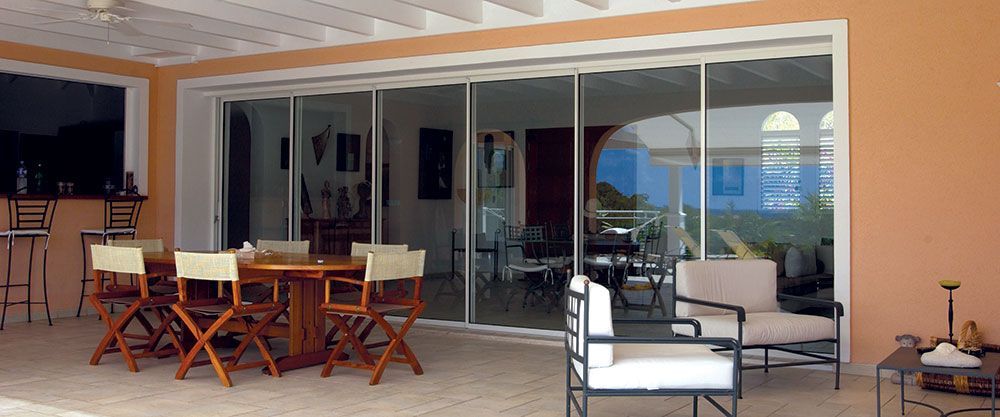 Série de baies vitrées collées les unes aux autres donnant accès à une terrasse couverte