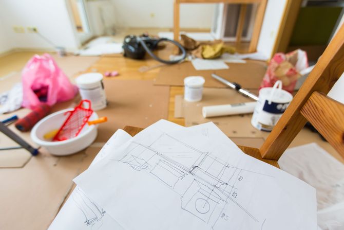 Bocetos y materiales de arte esparcidos sobre una mesa con un dibujo en primer plano.
