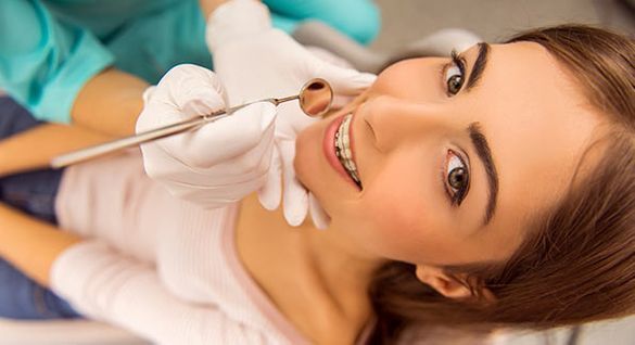 Una mujer está siendo examinada por un dentista.
