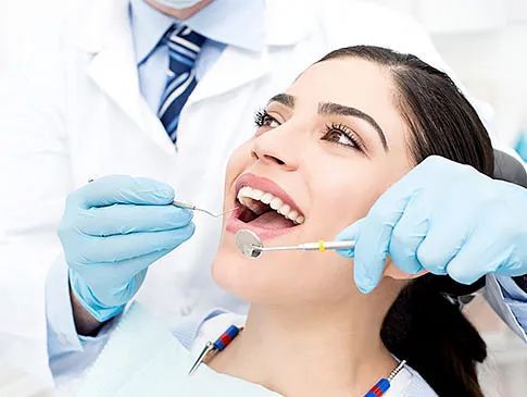 Una mujer está siendo examinada por un dentista.
