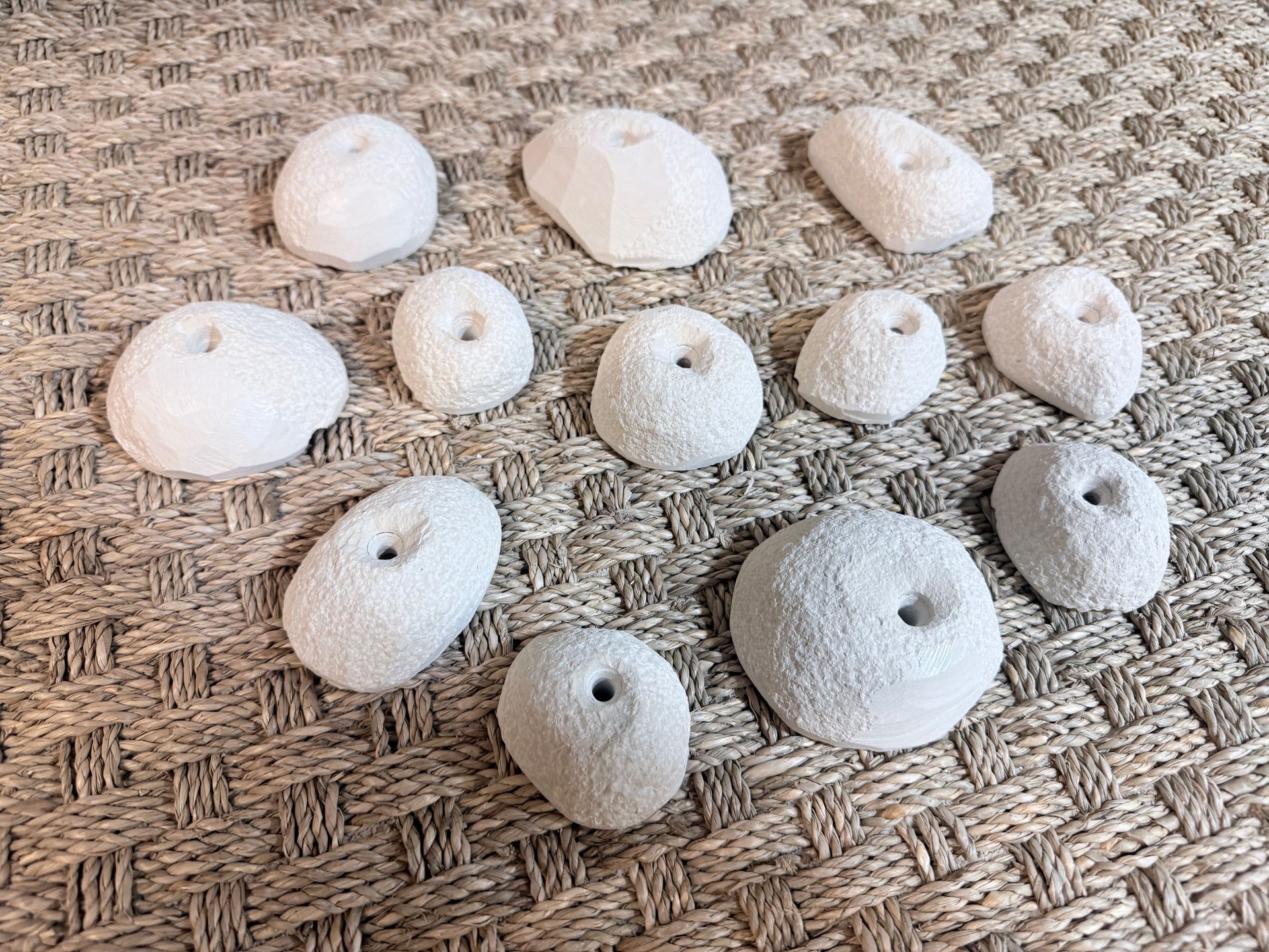 11 pierres blanches, texturées et poreuses de tailles et de formes rondes disposées sur une surface tissée.