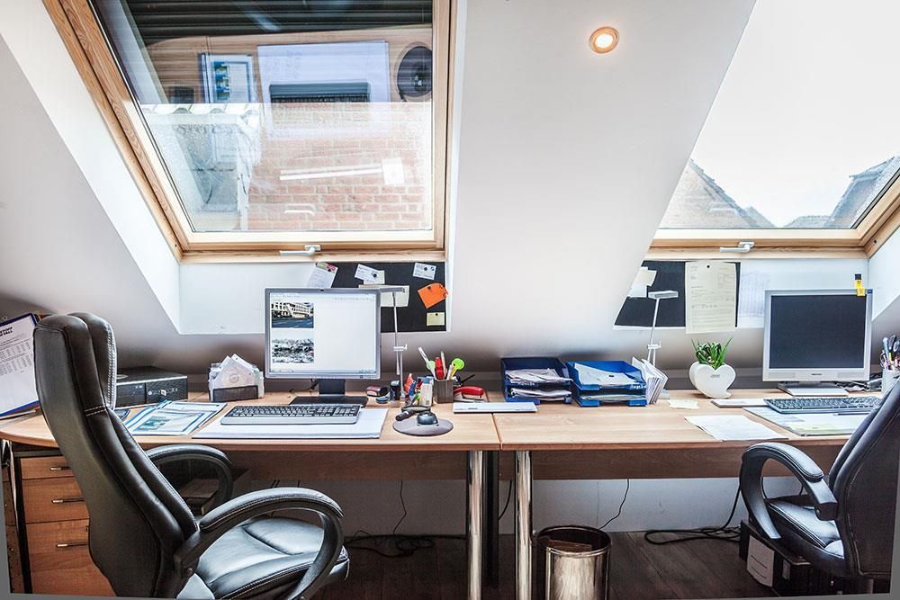 Ein Dachgeschossbüro mit zwei Schreibtischen und zwei Stühlen