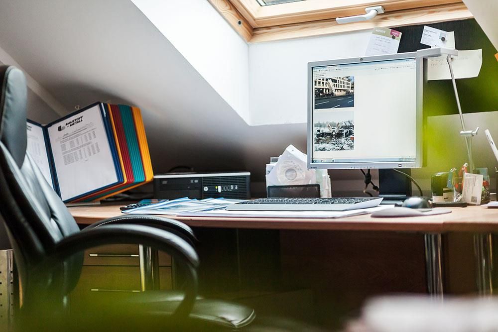 Ein Stuhl steht vor einem Schreibtisch mit einem Computer darauf