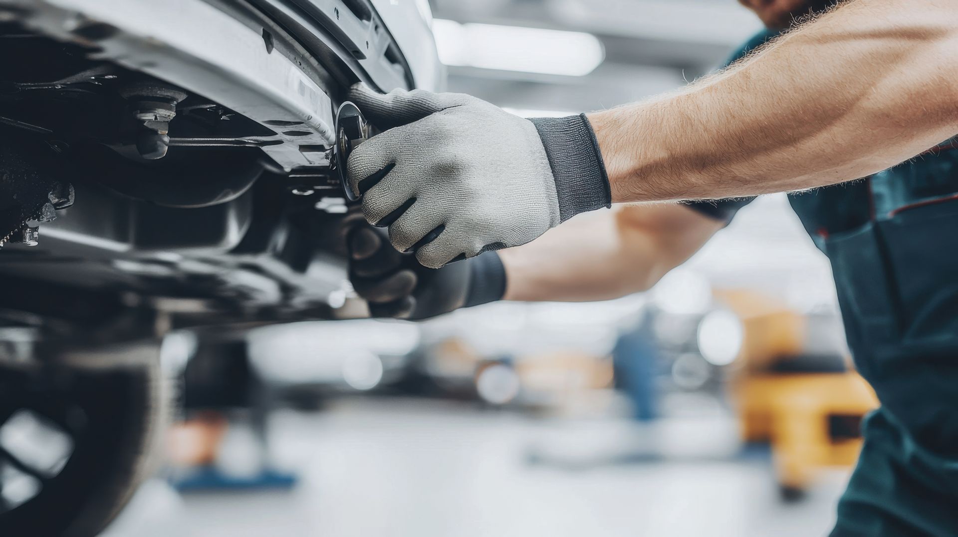 Gros plan sur les mains d'un mécanicien sur une voiture