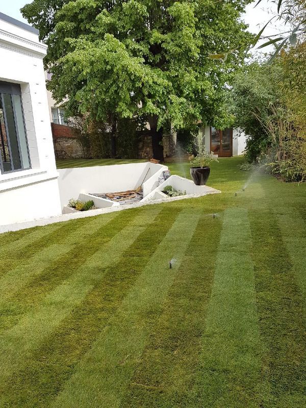 Jardin tondu avec des arroseurs automatiques en fonctionnement
