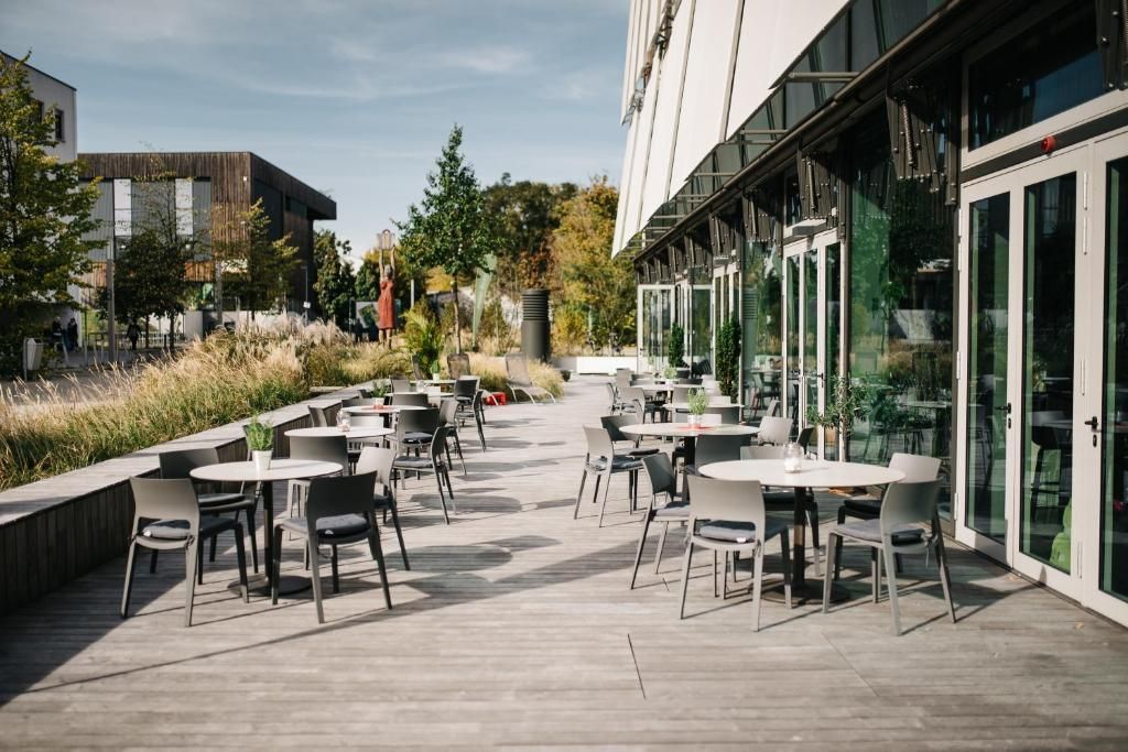 Eine Terrasse mit Tischen und Stühlen außerhalb eines Gebäudes