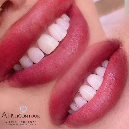 Primer plano de labios carnosos con un intenso color rojo. Se ven dientes blancos y brillantes, sonriendo.