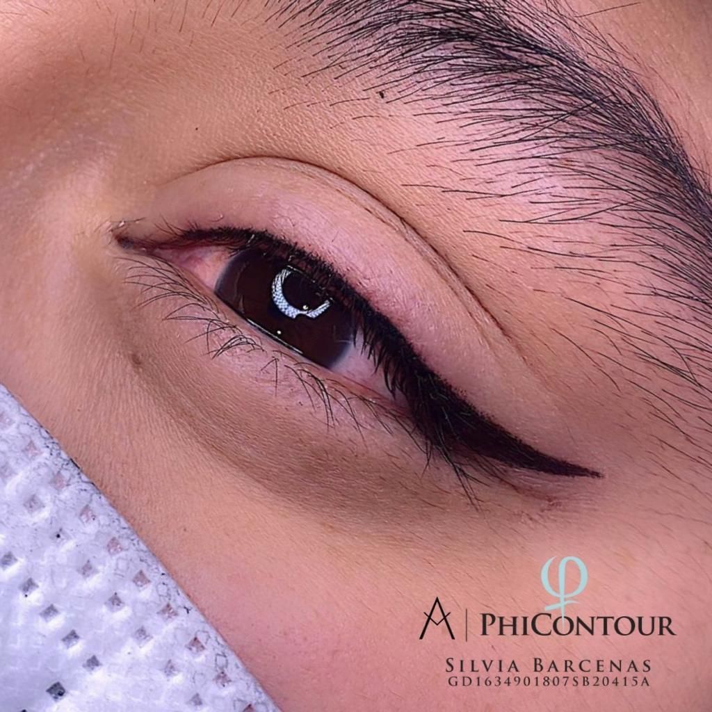 Primer plano de un ojo con delineador permanente. Una elegante línea negra se extiende hacia afuera.