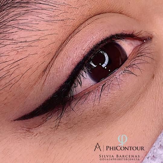 Primer plano de un ojo con delineador permanente. Una línea negra gruesa y alada realza el párpado superior.