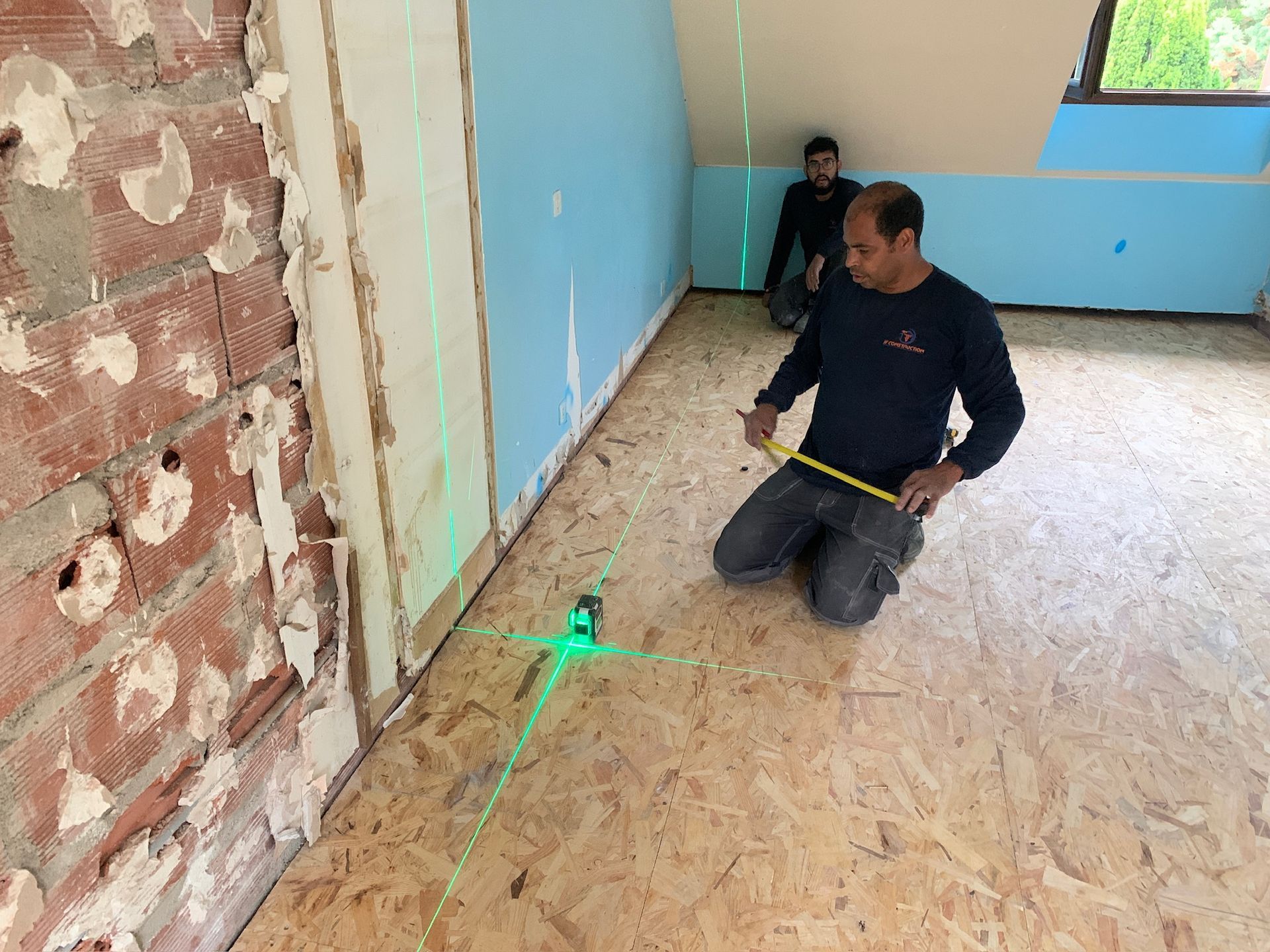 Des artisans qui prennent des mesures sur un chantier