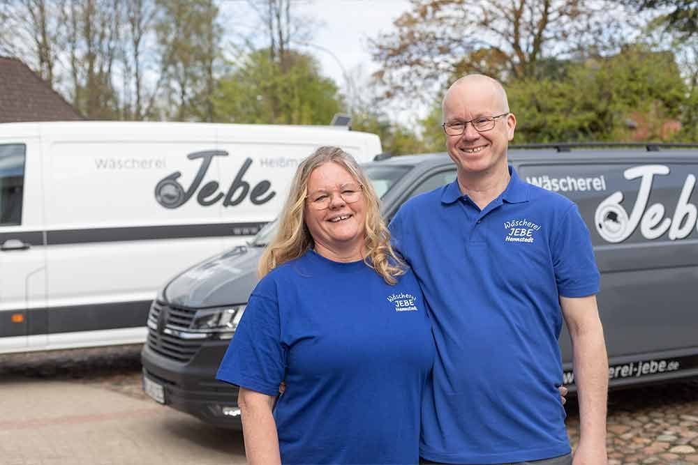 Ein Mann und eine Frau posieren vor einem Lieferwagen für ein Foto.