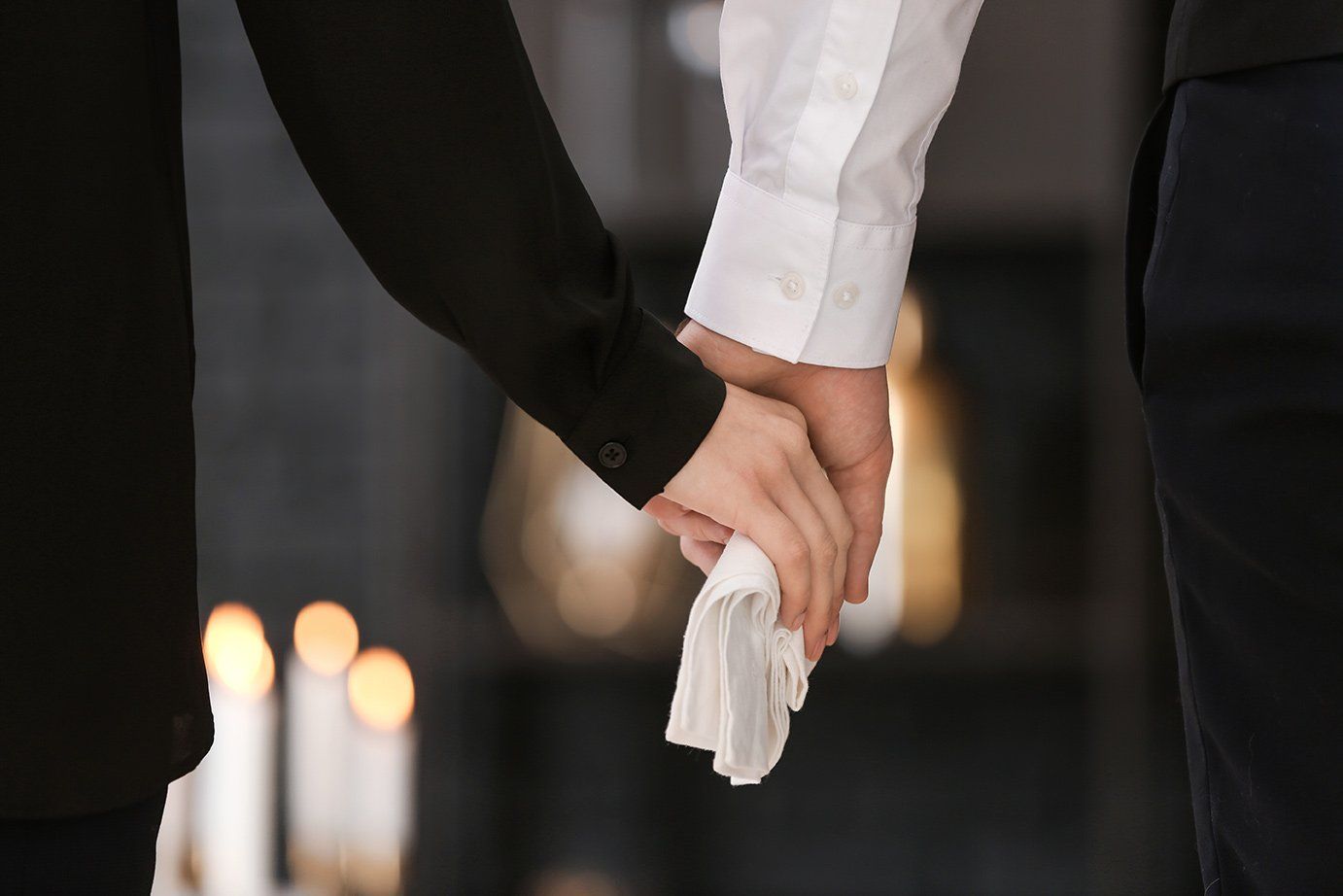 Personnes se tenant la main durant une cérémonie funéraire