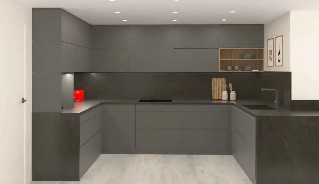 Una cocina con gabinetes grises y encimeras negras.