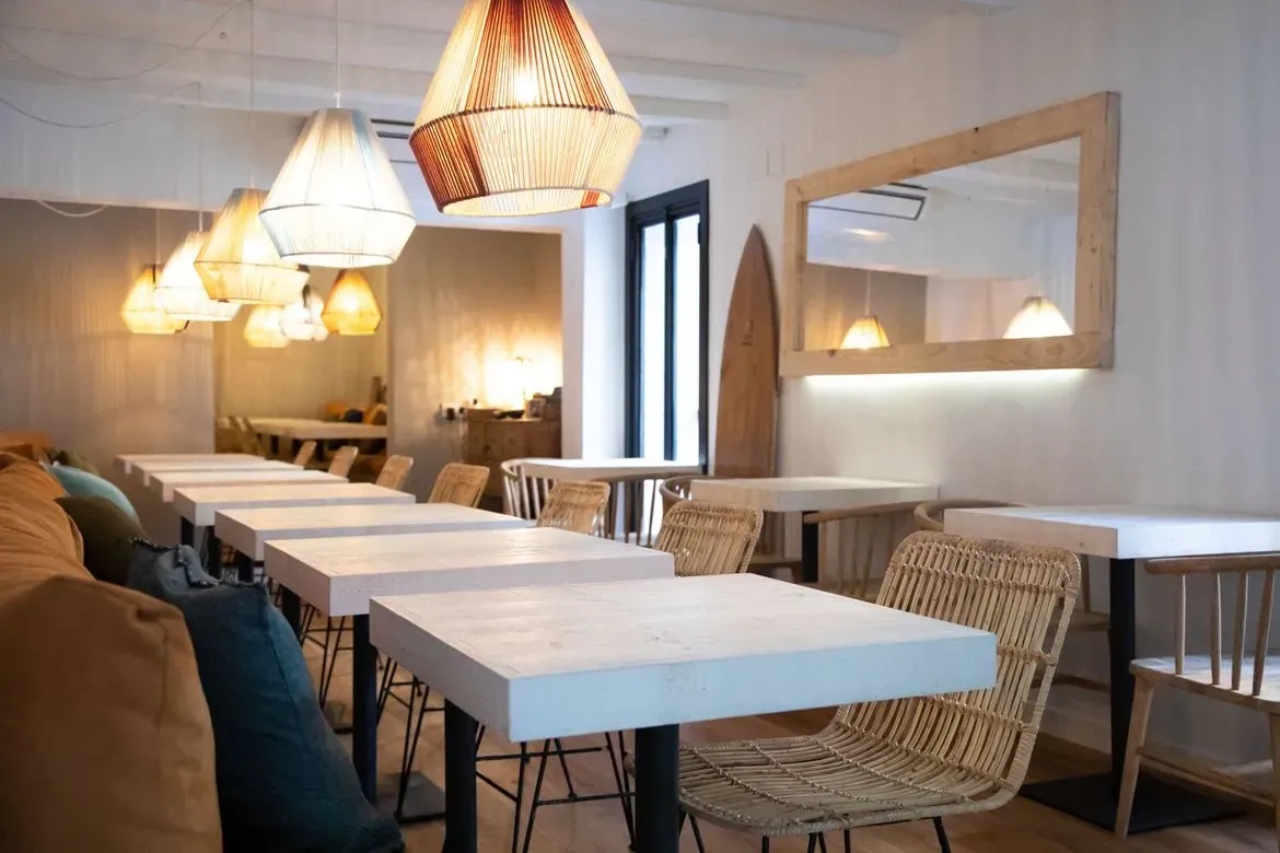 Un restaurante con mesas y sillas y un espejo en la pared.
