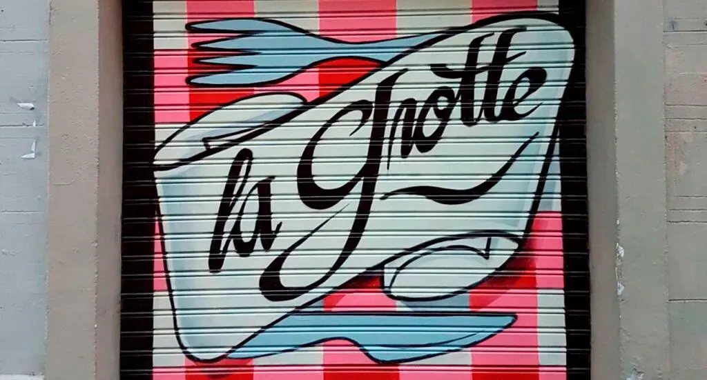 Un cartel en la puerta de un garaje que dice la grotte
