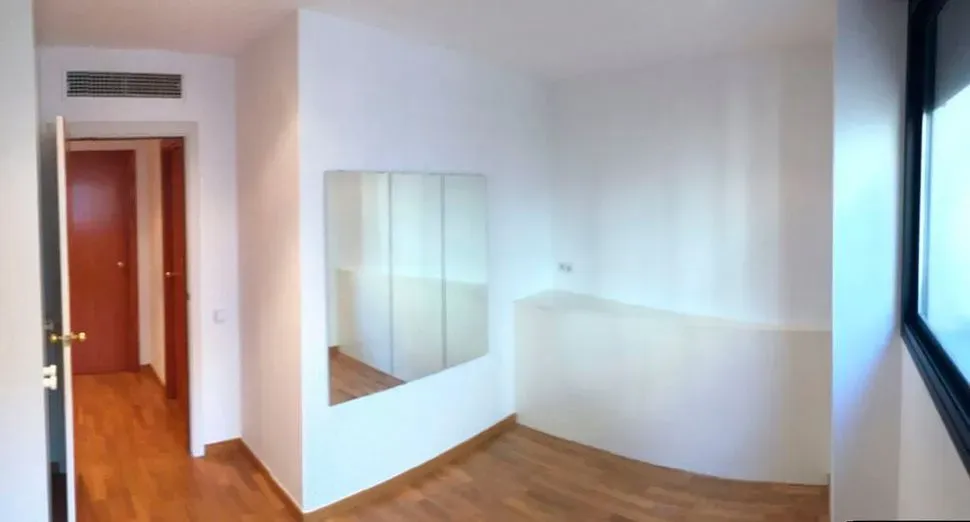 Un dormitorio con un gran espejo en la pared.