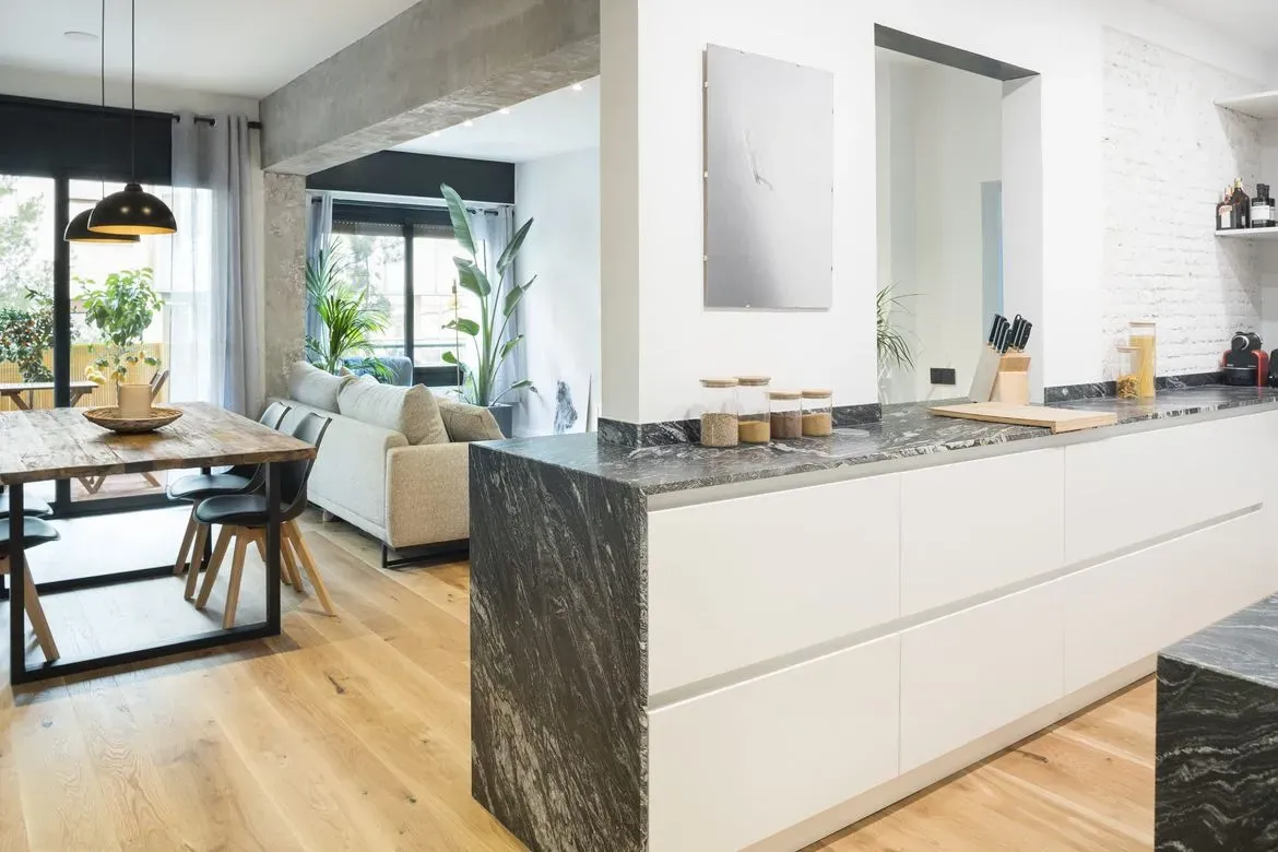 Una cocina con una mesa de comedor y un sofá al fondo.