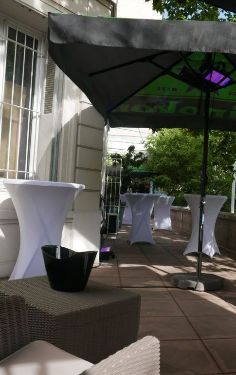 Une terrasse avec des tables blanches