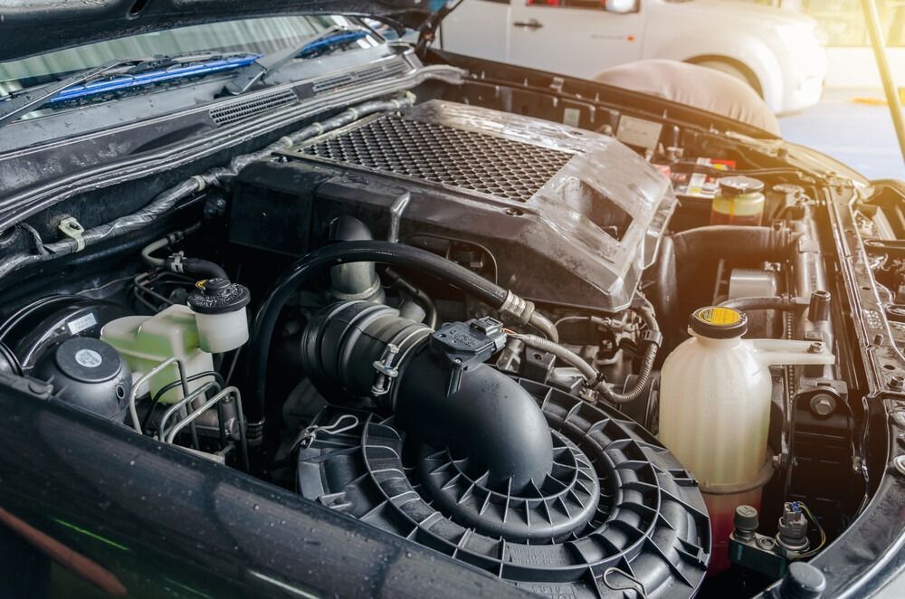 Un primer plano del motor de un automóvil con el capó abierto.