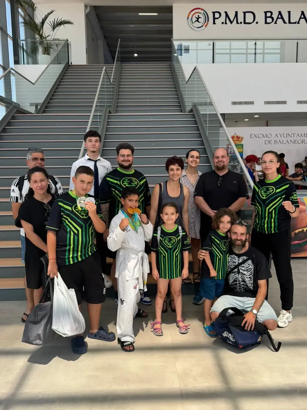 Un grupo de personas, algunas vestidas con uniformes deportivos a juego de color verde y negro