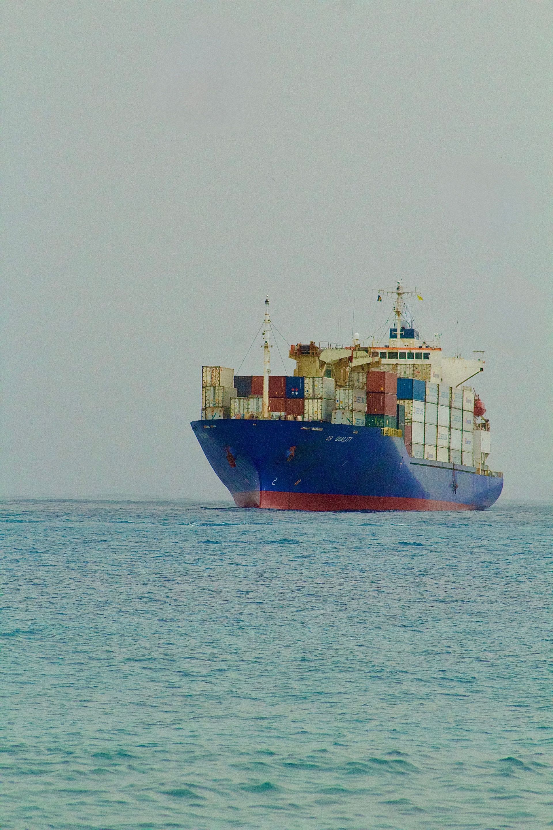 Cargo sur une mer calme sous un ciel pâle