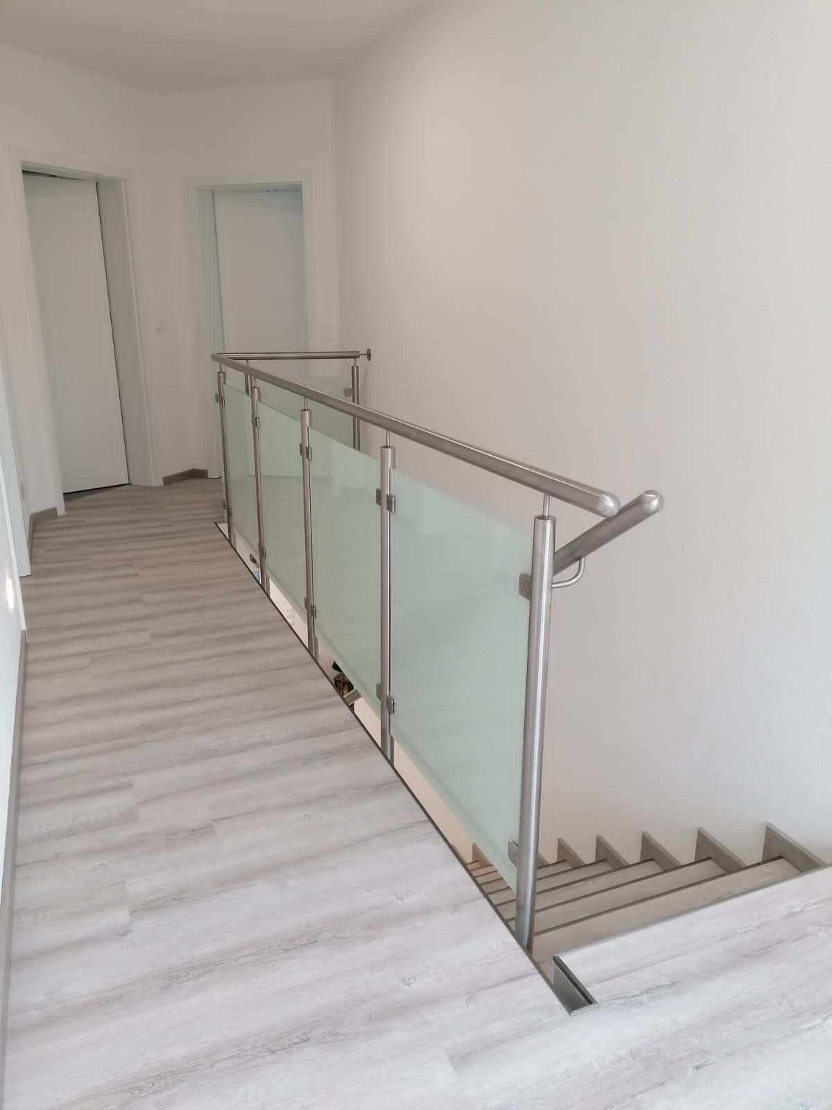 Installation eines Metallzauns. Der Arbeiter schraubt die Schraube in den Metallzaun.