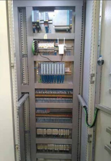 Un gran panel de control eléctrico con muchos cables que salen de él.