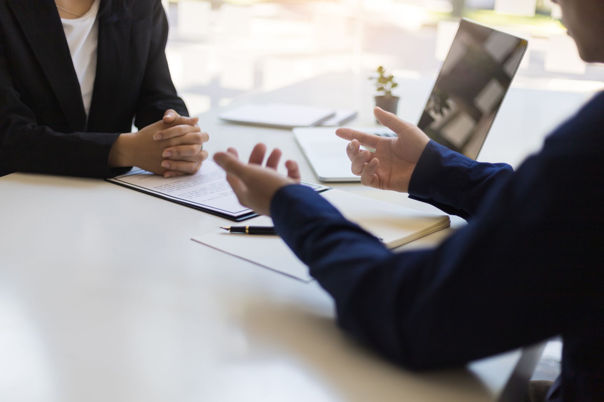 Un homme et une femme sont assis à une table et ont un entretien d'embauche.