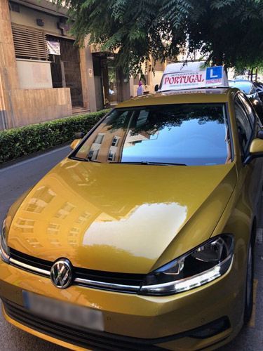 Un Volkswagen Golf amarillo está estacionado al costado de la carretera.