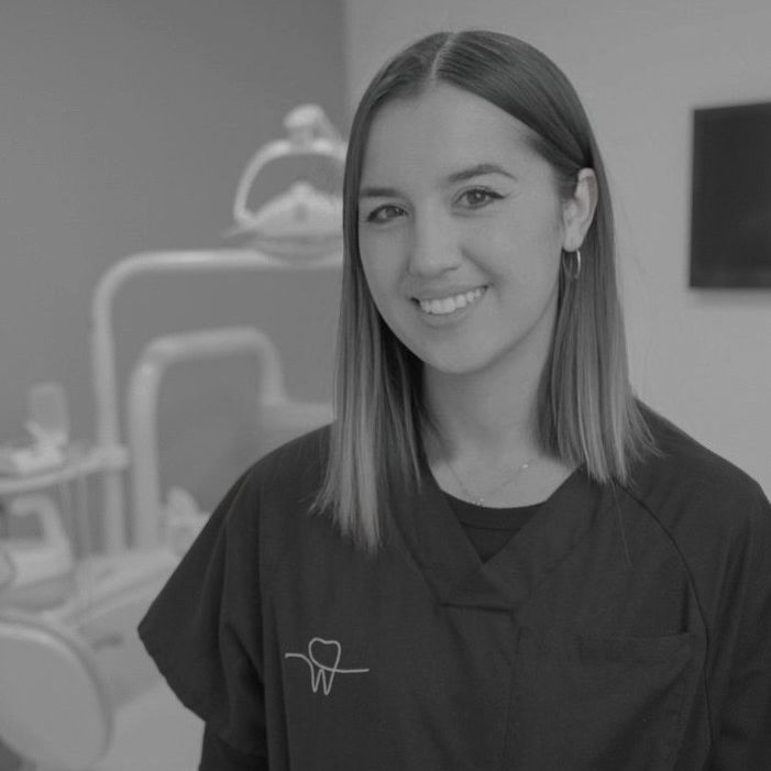 Profesional dental sonriendo en un consultorio dental.