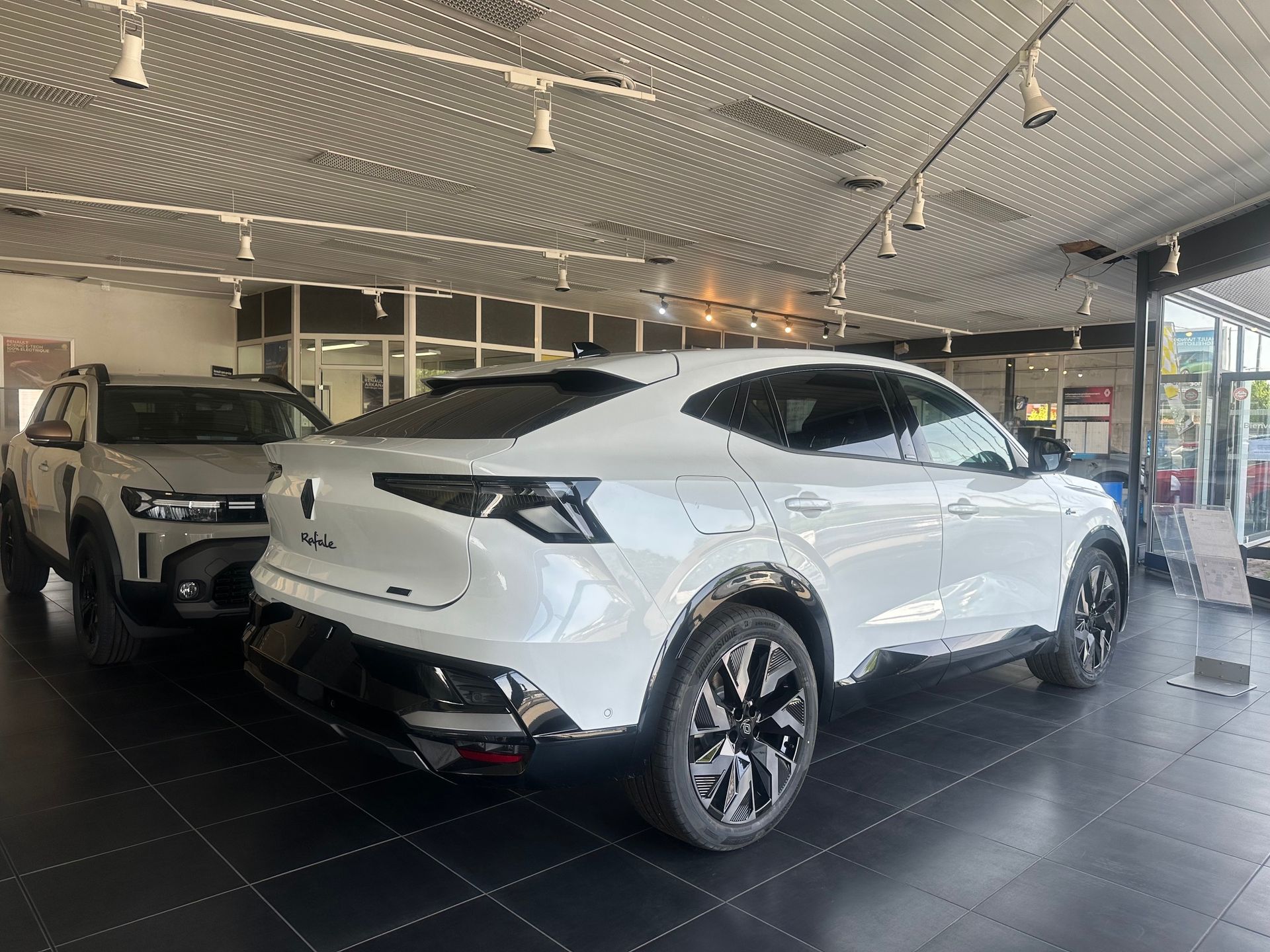 SUV blanc exposé dans une salle d'exposition, vu de trois quarts arrière.