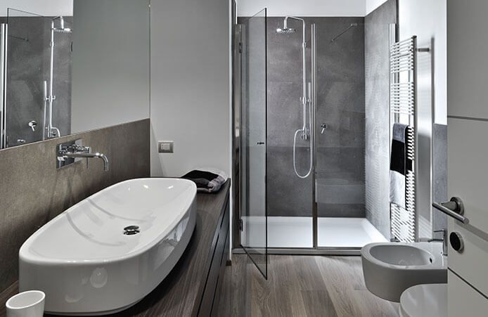 Salle de bains moderne grise avec baignoire îlot, douche en verre et lavabo mural