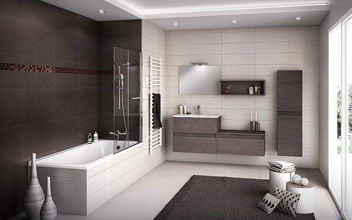 Salle de bains moderne avec baignoire, douche, meuble-lavabo suspendu et murs carrelés gris.