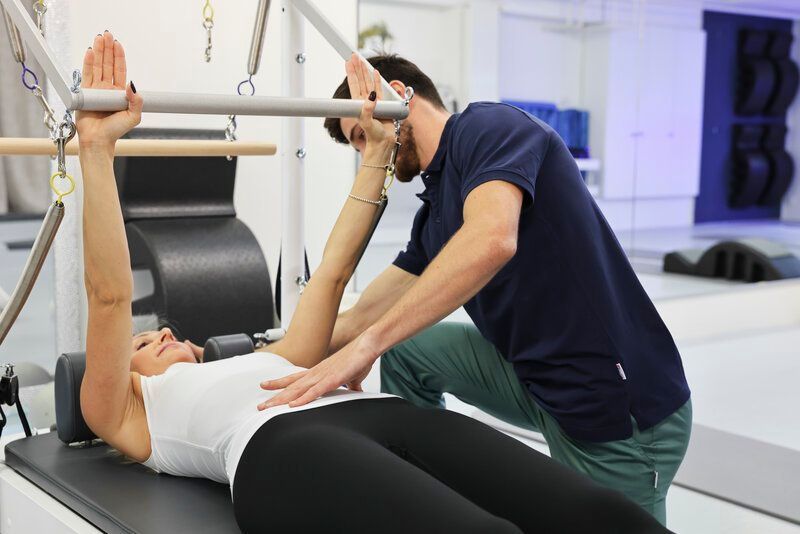 Eine Frau liegt in einem Fitnessstudio auf einer Yogamatte.