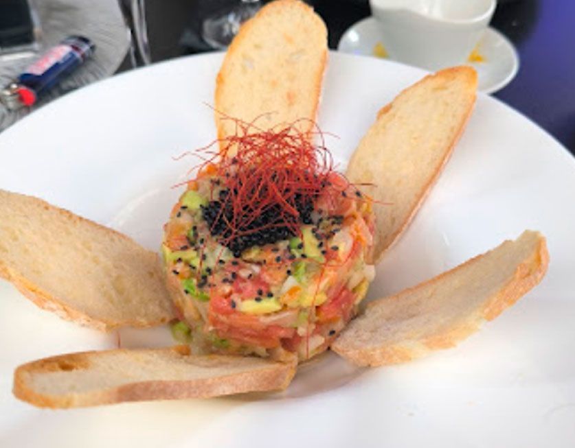 Un plato blanco cubierto con ensalada y rebanadas de pan.
