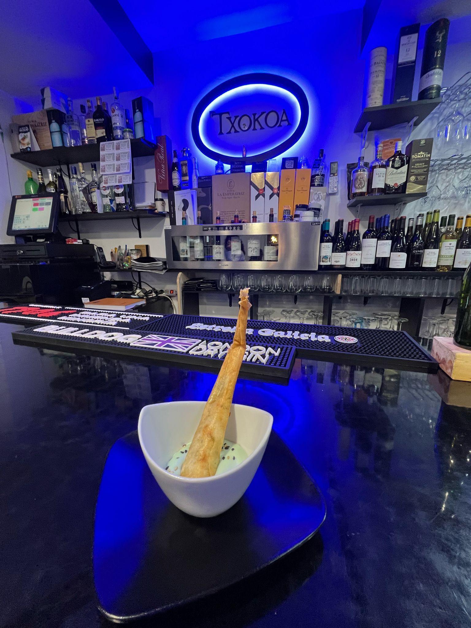 Un plato de comida está sobre una mesa delante de un bar.